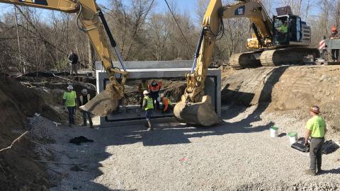 Box culvert construction with workers and excavators