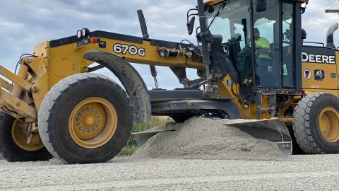 Equipment grading limestone road.