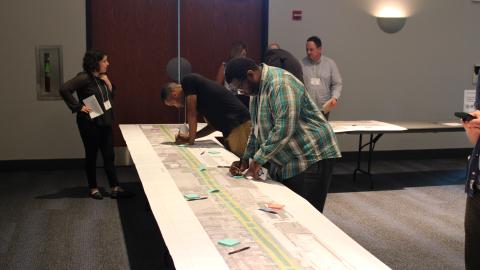 Residents and community members look at Mound Road construction plans