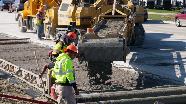 Construction workers pour concrete on Mound Road