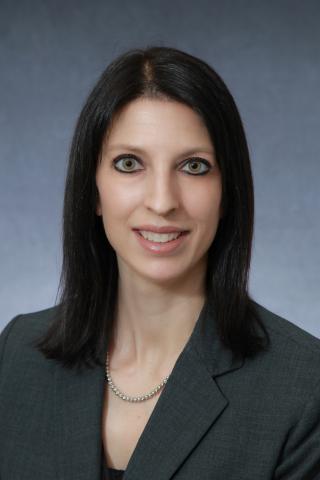 Smiling dark haired woman in a suit